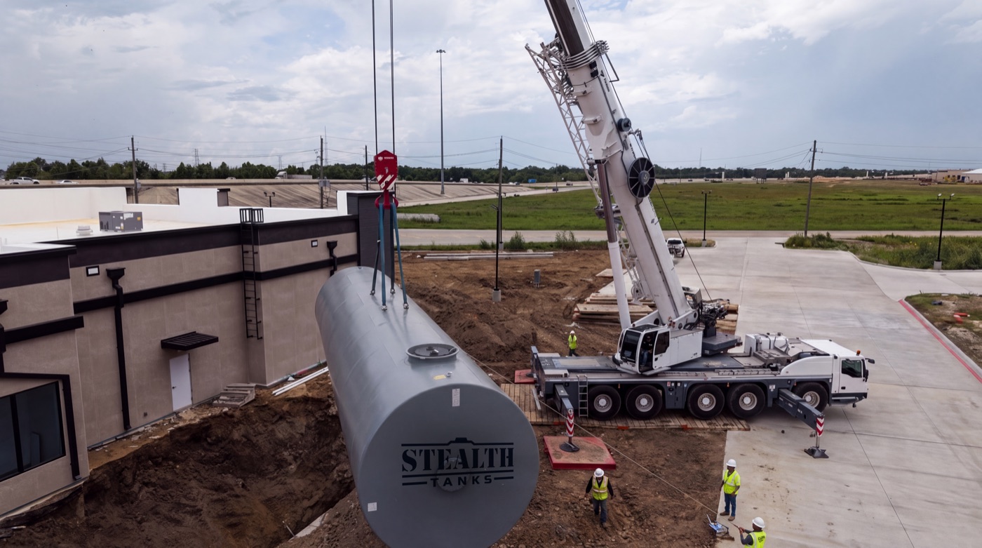 Crane lowering a Stealth Tanks UST into the excavation